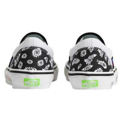 A pair of Vans slip-on sneakers shown from the back, featuring a black canvas upper with a white graphic pattern, white rubber soles, and bright green Vans 'Get Up The Way' logos on the heel.