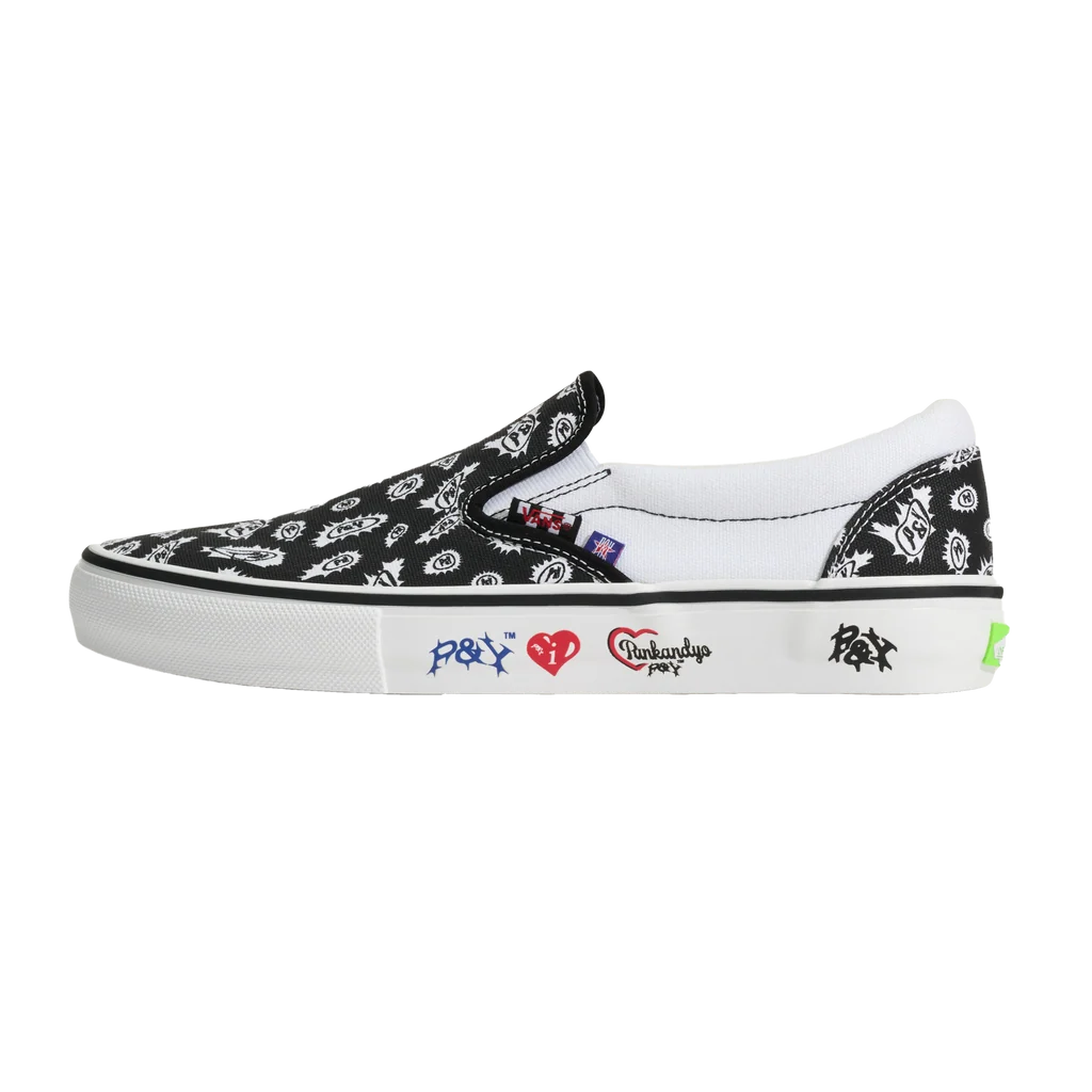 A black slip-on platform sneaker with a white bandana print, featuring white side patches with red and blue graphics, on a solid white background.