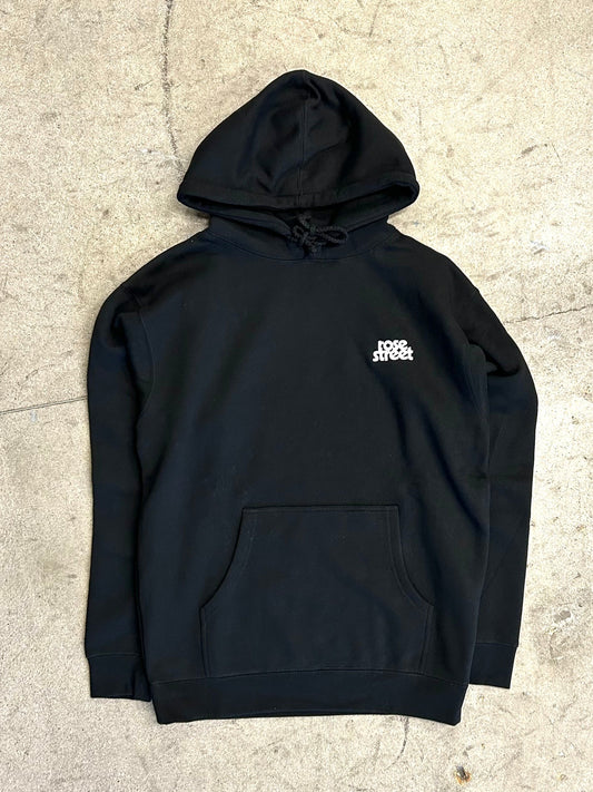 Black hoodie with a logo on the chest against a textured beige background