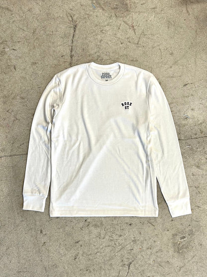 White long-sleeve shirt with a logo on a concrete floor
