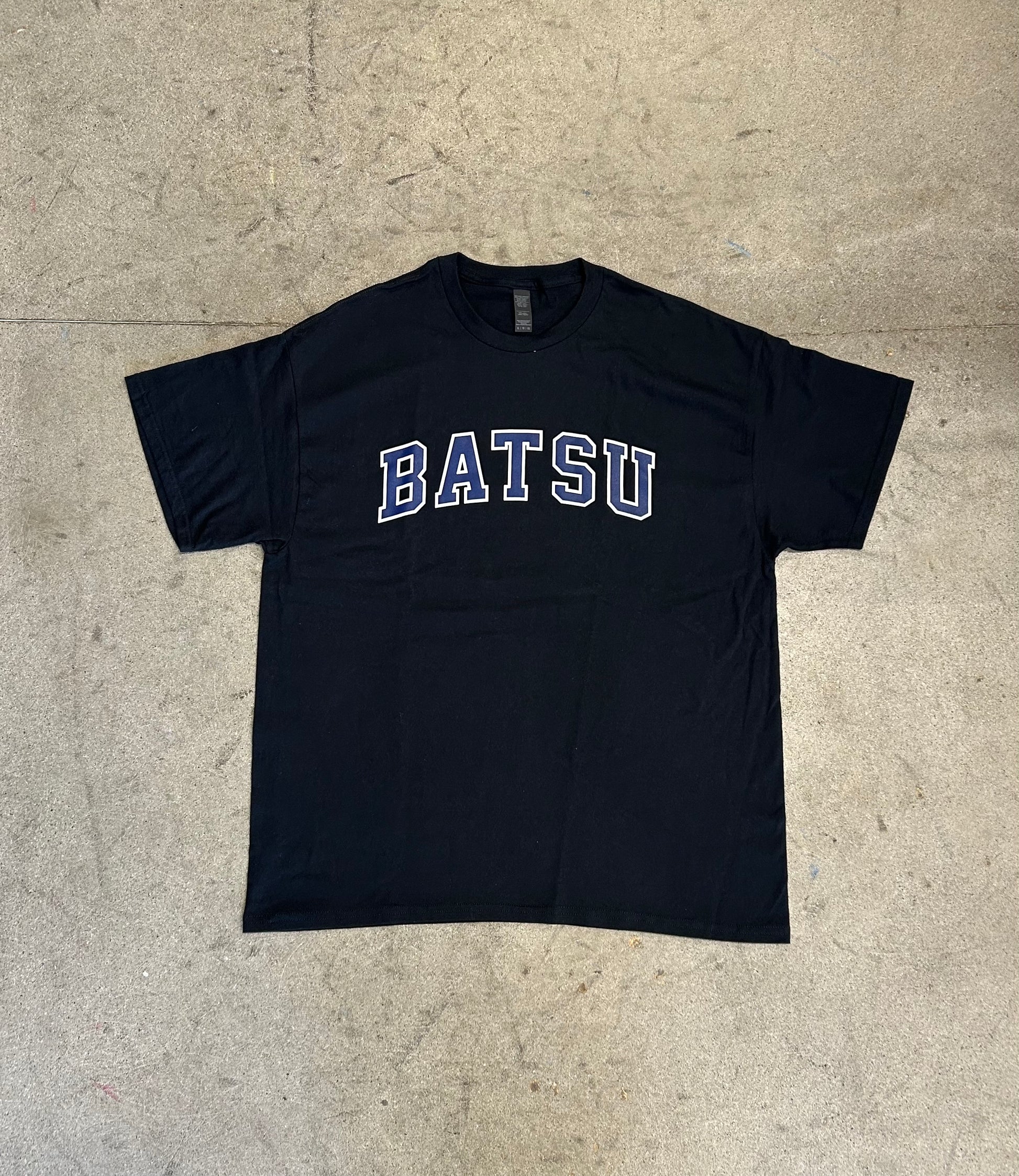 Black t-shirt with 'BATSU' text on a beige surface
