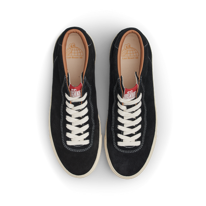 Pair of black sneakers with white laces on a white background