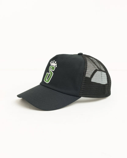 A black trucker-style baseball cap with a curved brim, black mesh back panels, and a green and white embroidered logo on the front, shown against a plain white background.