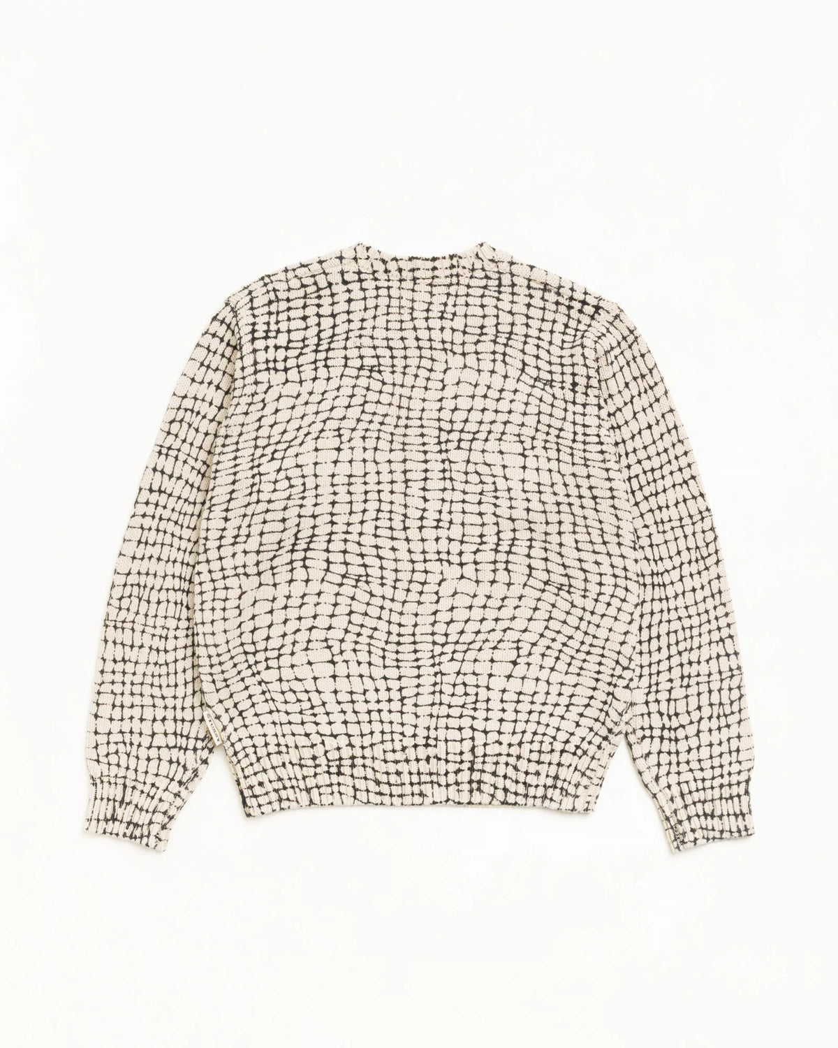 A long-sleeve knit sweater with a textured black and off-white grid pattern, laid flat against a solid white background.