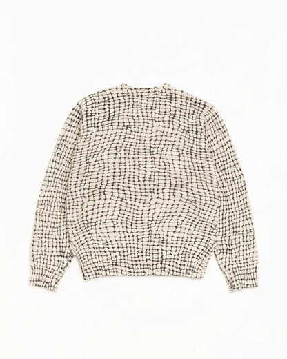 A long-sleeve knit sweater with a textured black and off-white grid pattern, laid flat against a solid white background.