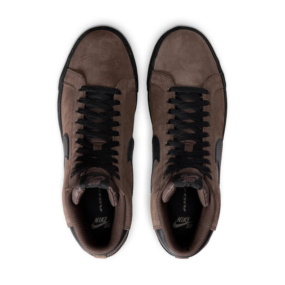 Pair of brown sneakers with black laces on a white background